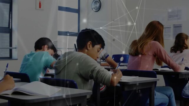 Front-left student writing as camera panning right, revealing rows, network graphic aiding learning