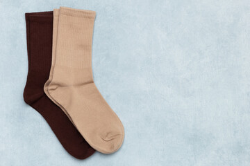 Colored beige and brown socks on gray textured background with copy space. Top view, flat lay. © Natalia Mir