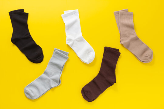 Colorful neutral socks on a bright yellow background with copy space pattern.  Flat lay. Top view.