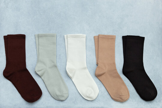 Colored socks on a gray textured background with copy space. Top view, flat lay.
