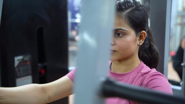 Indian Woman Performing Butterfly Exercise on Pec Deck Machine During Chest Workout in Modern Gym