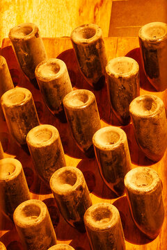 Champagne bottles on wooden racks in the traditional process of riddling (remuage) in sparkling wine production in underground chalk cellars of Reims, Champagne province of France