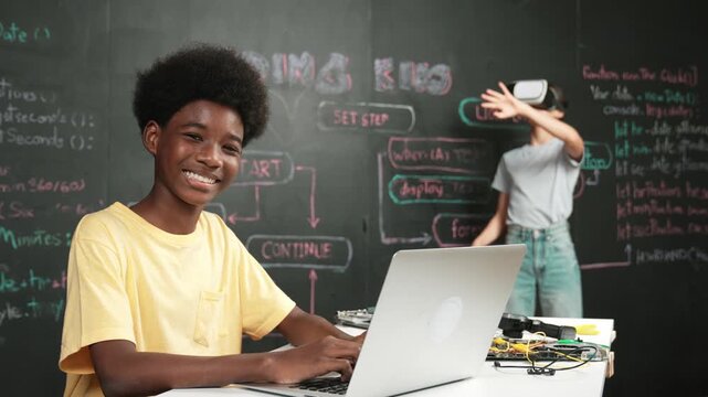 Smart african student programming and coding innovative system while caucasian girl enter in metaverse or virtual world by using VR or head set at blackboard in STEM technology classroom. Edification