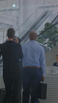 Vertical video: Business travelers moving in lobby queue with bag as center man checking in at desk