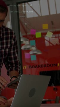 Vertical video: Dev tapping tablet and switching to laptop in BOARDROOM tech code reacting for demo