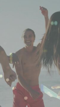 Vertical video: Shirtless man moving forward after arms sweep, cheering for marketing by ocean