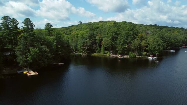 Aerial over Buckskin Lake on a summer afternoon towards lakeside cottages among the expansive crown land wilderness in the Tory Hill, Highlands East, in southern Ontario, Canada. 