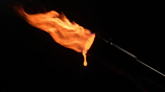 A burning flame melts drips down from a hot glowing torch
