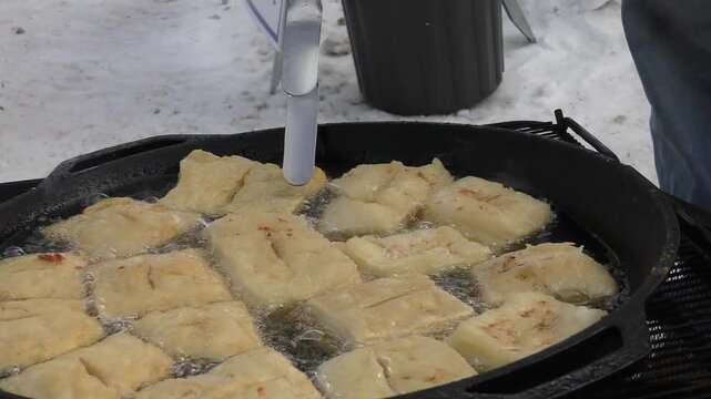 Bannock Banuk frying dough - bread - donut in oil on open bonfire