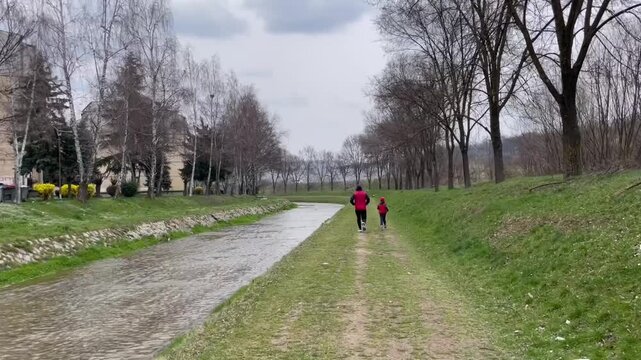 A father and his young son are playing sports; father and son are running; healthy lifestyle; child-rearing; family; family love 