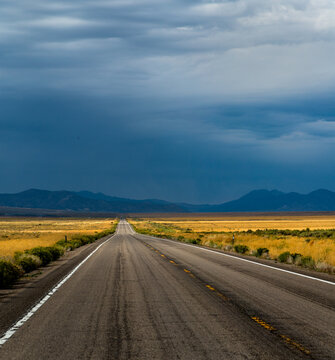USA, NV, Ely.  Long empty highway heading for distant mountains. Nevada Route 50 