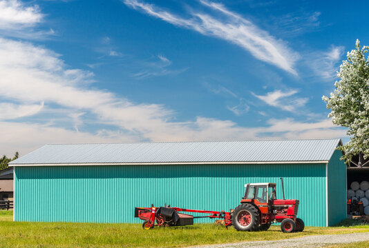 Canada, BC, Chilliwack.  Farm tractor in front of nice, clean, new farm building in the Fraser Valley.  