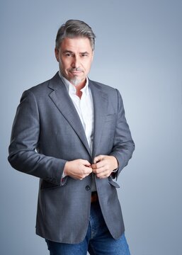 Business portrait of older businessman against gray background.
