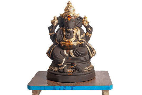 Ganesha statue with gold accents on wooden pedestal for decor and worship.