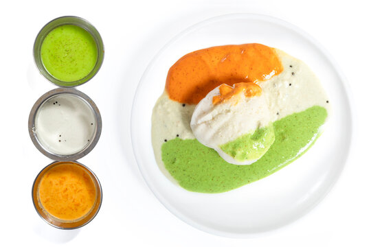 Three varieties of chutney with idli on a white plate, South Indian food