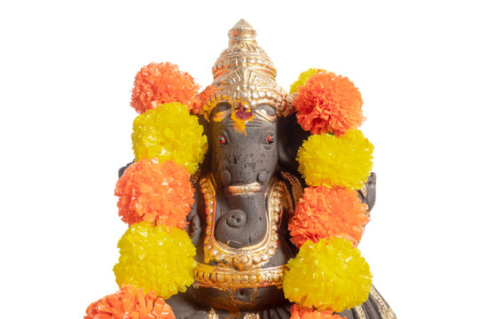 Ganesha idol adorned with a bright orange and yellow floral garland for Hindu worship and celebration.