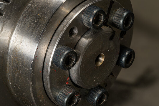 Detail of bolts on a gearbox near the stainless steel section.