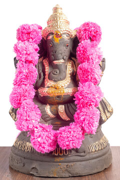 Ganesha idol adorned with pink flower garland for Ganesha Chaturthi festivals.