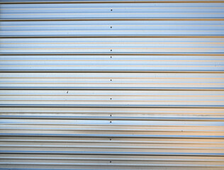 Fototapeta premium Close‑up texture of shiny silver corrugated tin siding 