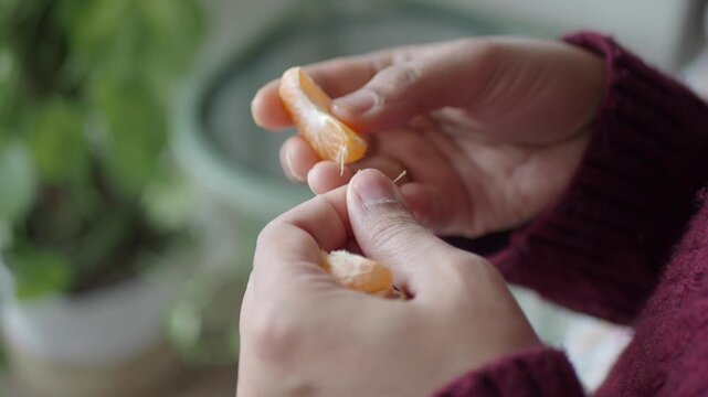 Holding a peeled mandarin with a green background