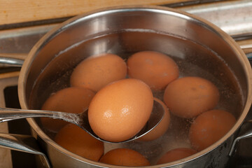 We cook brown eggs in a pot.