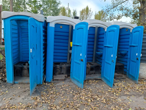 Blue plastic toilet cabins with open doors