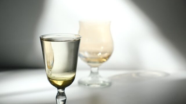 Crystal glassware. Vodka,  hard alcoholic drink, brandy from fermented fruits. Bar counter. Cocktail, brandy, vodka. High contrast light capturing cinematic atmospheric mood