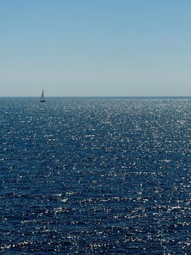 Blue glittering sea and sailing boat.