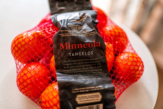 Roseland, USA - March 28, 2025: Minneola tangelos citrus fruit sweet fruits food in mesh net bag with Private Selection kroger brand sign label