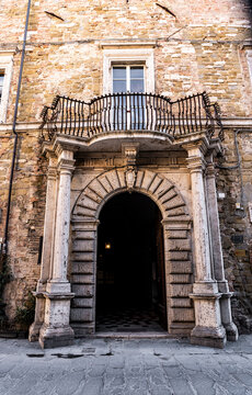 The rusticated portal of Palazzo Salvatori in Piazza Ignazio Danti, with bossage stonework, wooden door and a wrought-iron balcony above, in Perugia, Umbria, Italy.