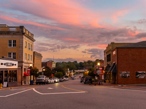 BELMONT, NC -October 2024: A vibrant  sunset glows over the historic brick buildings of Main Street in downtown Belmont. The scene features local landmarks like Nellie's Southern Kitchen