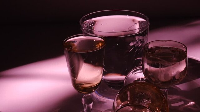 Drinking glasses. Buffet. Various glasses for alcohol and soft drinks. Dark, refraction light, red and purple colors