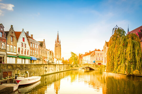 scene of old town with canal and tower of Vrouwekerk , Belgium