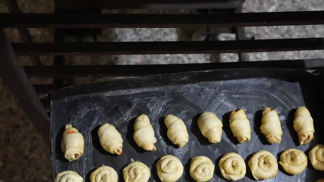 Baker placing tray of croissant argentinian on rack
