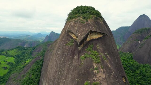 Aerial view of "Pedra da Coruja", a striking inselberg formation in the rural area of Aguia Branca/ES, Brazil. This massive granite outcrop resembles the shape of an owl, standing out in the landscape
