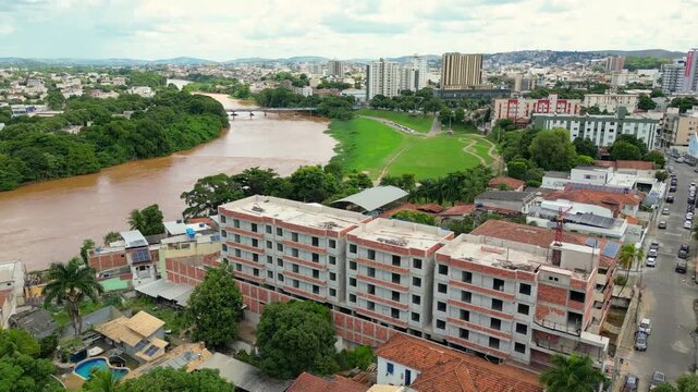 Aerial drone flyover of the city of Governador Valadares, Minas Gerais, Brazil, located along the banks of the Doce river. The footage captures the cityscape, surrounding riverfront, and key landmarks