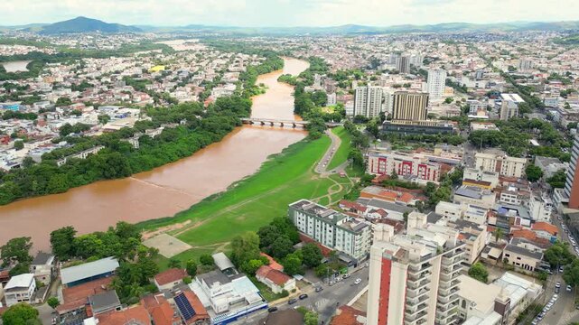 Aerial drone flyover of the city of Governador Valadares, Minas Gerais, Brazil, located along the banks of the Doce river. The footage captures the cityscape, surrounding riverfront, and key landmarks