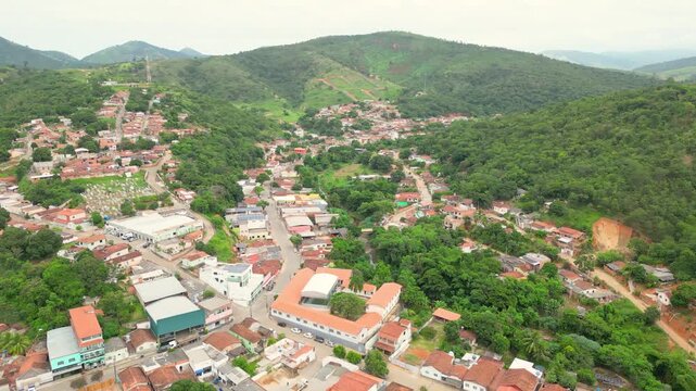 Aerial drone flyover of the city of Divino das Laranjeiras in Minas Gerais, Brazil. The footage captures the urban layout, surrounding countryside, and key landmarks of this small town