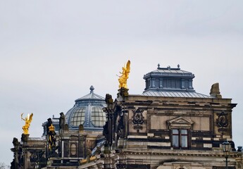 Luxurious rooftop display. Decorative gilded angels with historic architectural features shine brightly © Vladimir