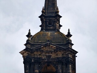 Decorative Gothic Tower. Detailed Baroque Steeple Set Against Overcast Sky with Conservation Elements © Vladimir