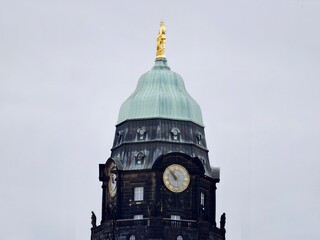 Traditional civic tower with aged copper surface and intricate architectural detailing emphasizing history © Vladimir