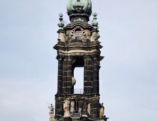 Artistic bell tower with detailed features. Ornamental steeple featuring arched openings and carved recesses © Vladimir