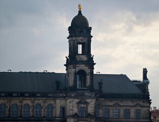 Fototapeta premium Storm clouds shadow ornate civic structure. Clouds brew over ageold architectural landmark towering high