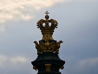 Obraz premium Golden crown outline. Ornate crown shape set against stormy skies with aged texture and dramatic lighting