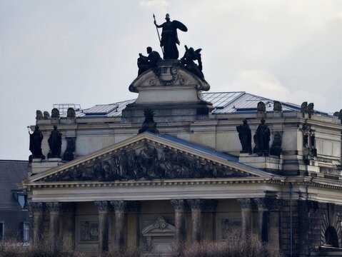 Ornate pediment features equestrian statues and symbolic groupings with prominent skyline silhouette