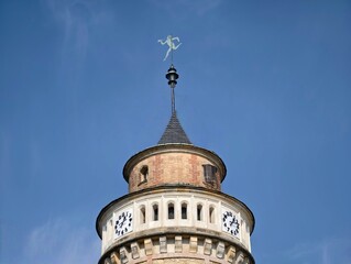 Clock tower skyward. Circular clock faces under clear sky with shining weather vane and elegant crown © Vladimir