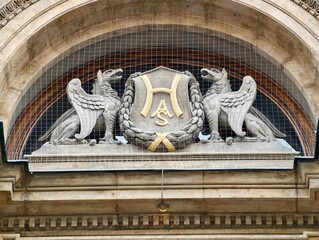 Decorative limestone emblem. Detailed limestone facade featuring griffins and emblems for restoration themes © Vladimir