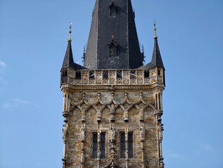 Decorative stone tower with windows. Vertical stone spire featuring ornate carvings and narrow openings © Vladimir