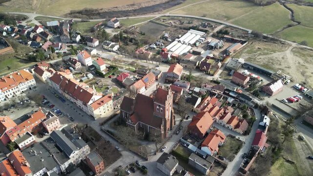 Gniew - Polska - stare miasto z pięknym kościołem i zamkiem krzyżackim nagrane dronem w słoneczny dzień