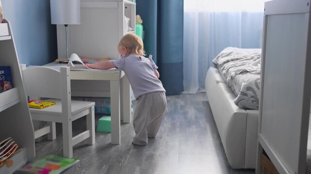 Baby first steps. baby girl goes across room learns to walk to take first steps